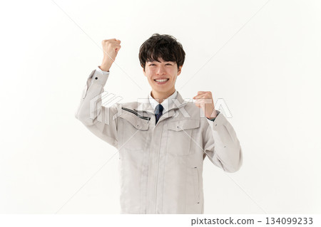 穿著工作服的年輕人，握拳 134099233
