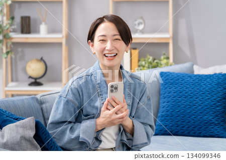 客廳裡有智慧型手機的女人 134099346