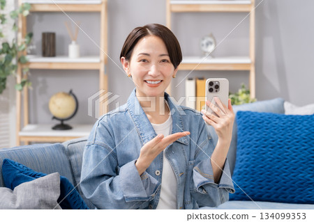 一名女子手持智慧型手機，揮舞著手 134099353