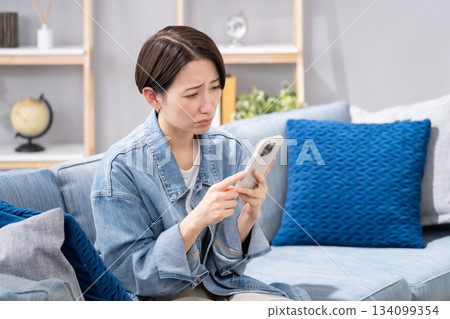 A woman with a smartphone worries 134099354