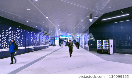 Warsaw, Poland. 28 November 2025. Commuters going through the underground passage hall at Warszawa Zachodnia train station. Ceiling mounted large artificial illumination. Warsaw, Poland. 28 November 2025. Commuters going through the underground passage hall at Warszawa Zachodnia train station. Ceiling mounted large artificial illumination. 134099365