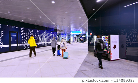 Warsaw, Poland. 28 November 2025. Commuters going through the underground passage hall at Warszawa Zachodnia train station. Ceiling mounted large artificial illumination. 134099382