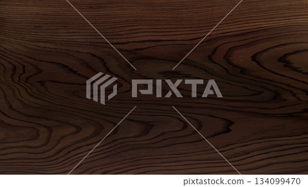 A background image of a dark brown table with beautifully defined undulating wood grain 134099470