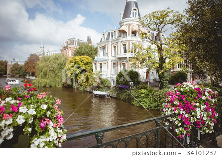 Flat design showing ornate canal house, wrought-iron railing, flower baskets and moored boat Flat design showing ornate canal house, wrought-iron railing, flower baskets and moored boat 134101232