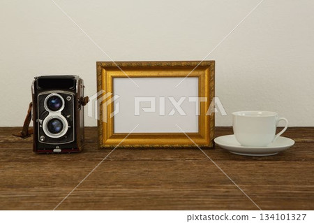 Photo frame, camera and coffee cup on table Photo frame, camera and coffee cup on table 134101327