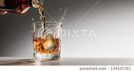 Smooth whiskey pour into an ice-filled glass with a clean white background 134101781