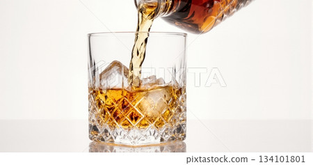Smooth whiskey pour into an ice-filled glass with a clean white background 134101801
