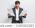 A middle-aged white man dressed in a suit holds papers in his hands, on a white background 134102263