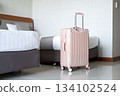 Luggage positioned next to comfortable hotel bed, highlighting travel lifestyle and room interior 134102524