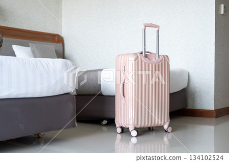Luggage positioned next to comfortable hotel bed, highlighting travel lifestyle and room interior Luggage positioned next to comfortable hotel bed, highlighting travel lifestyle and room interior 134102524