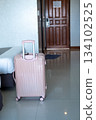 Suitcase standing by the bedside in modern hotel room, showcasing vacation arrival atmosphere 134102525