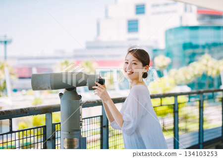 年輕女子透過望遠鏡欣賞旅遊景點的景色 134103253
