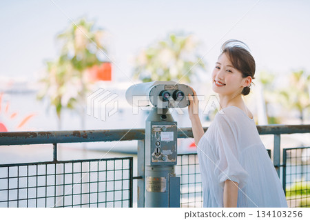年輕女子透過望遠鏡欣賞旅遊景點的景色 134103256