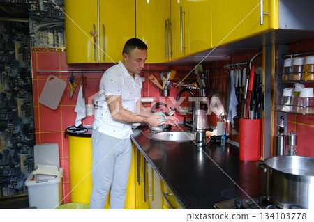 man washes a dishes, close-up of hands and sponge 134103778