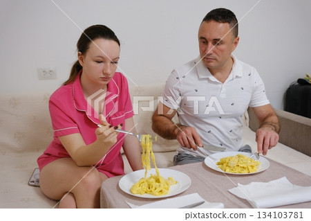 father and daughter having pasta dinner together at home father and daughter having pasta dinner together at home 134103781