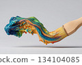 Paintbrush dripping colorful paint onto white paper creating art 134104085