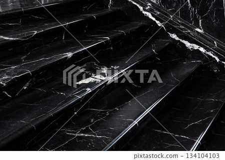 Close up polished black white marble stairs elegant texture bright veins creating dramatic contrast. Reflective surface adds depth subtle light enhances luxurious stone pattern architectural detail 134104103