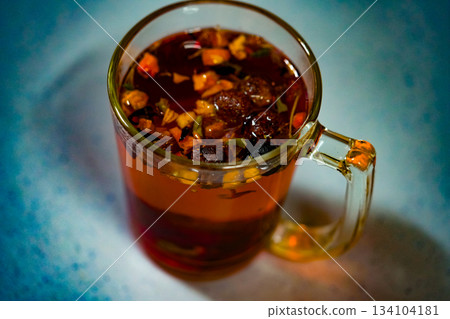 Fruit red tea with berries in glass cup on dark background Fruit red tea with berries in glass cup on dark background 134104181
