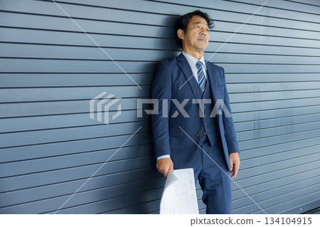 一位商人站在店鋪前沉思。 一位商人站在店鋪前沉思。 134104915