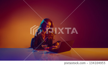 Smiling woman enjoying online casino gameplay at laptop Smiling woman enjoying online casino gameplay at laptop 134104955