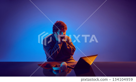 Young man reacting emotionally to unexpected online casino moment 134104959