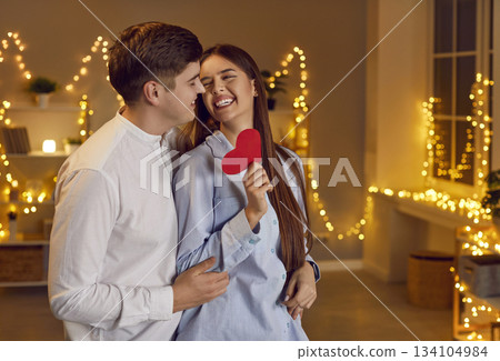 Young Couple Embracing and Holding a Red Heart on Valentine Day Young Couple Embracing and Holding a Red Heart on Valentine Day 134104984
