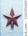 Pink glitter Christmas star ornament on snowy background 134105449