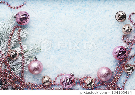 Pink Christmas ornaments on snowy blue background 134105454