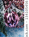 Pink Christmas ornament with beads on snowy winter background 134105456