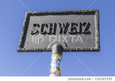 Border sign between Austria and Switzerland during hike to Schesaplana in Ratikon mountain range 134105783