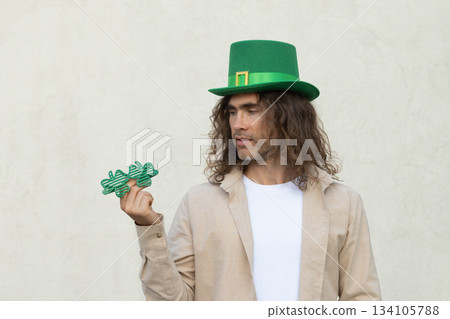 Man in green traditional hat choice shamrock clover glasses for St Patricks day celebration. Man in green traditional hat choice shamrock clover glasses for St Patricks day celebration. 134105788