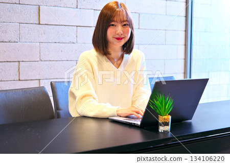 Woman staring at laptop screen at office desk Woman staring at laptop screen at office desk 134106220