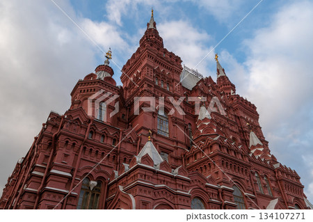 Grand Red Brick Cathedral-Style Building With Tall Towers and Spires Under Blue Sky Grand Red Brick Cathedral-Style Building With Tall Towers and Spires Under Blue Sky 134107271