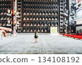 Tourist with backpack explores a grand temple hall adorned with many Buddha statues 134108192