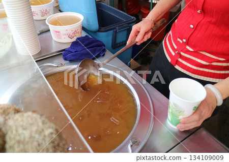 Taiwanese vendors are scooping grass jelly drinks. 134109009