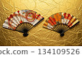 兩把精美的折扇展開在金色的日本紙上。 134109526