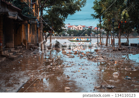 flooded city or town with buildings submerged in overflow water and mud, village underwater after heavy tropical rain and typhoon, consequences with dirt on the street 134110123