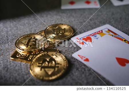Playing cards and bitcoin cryptocurrency tokens on table Playing cards and bitcoin cryptocurrency tokens on table 134110525
