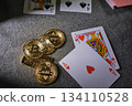 Playing cards and bitcoin cryptocurrency tokens on table 134110528