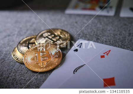 Bitcoin cryptocurrency coins with two playing cards Bitcoin cryptocurrency coins with two playing cards 134110535