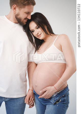 Couple sharing a moment during pregnancy in casual attire Couple sharing a moment during pregnancy in casual attire 134110722