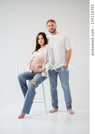 Couple poses together in studio for maternity shoot Couple poses together in studio for maternity shoot 134110783