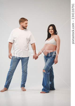 Couple poses together holding hands during pregnancy shoot Couple poses together holding hands during pregnancy shoot 134110791