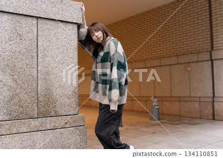 傾斜在牆壁的婦女 傾斜在牆壁的婦女 134110851