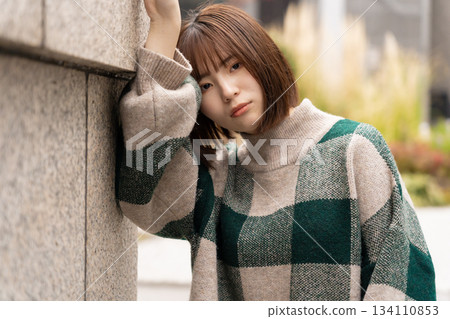傾斜在牆壁的婦女 傾斜在牆壁的婦女 134110853