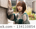 A woman leaning on the wall 134110854