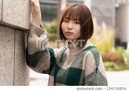 傾斜在牆壁的婦女 傾斜在牆壁的婦女 134110854