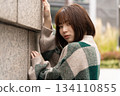 A woman leaning on the wall 134110855