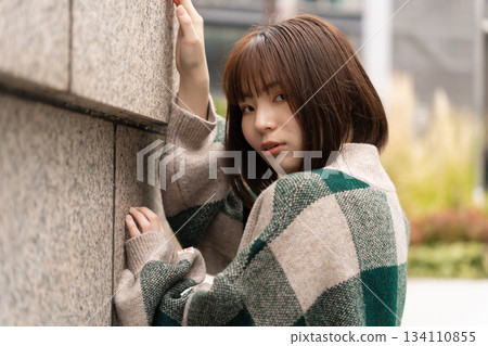 傾斜在牆壁的婦女 134110855