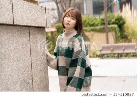 一名女子在建築物牆前擺姿勢拍照 134110987
